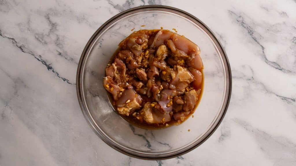 Boneless, skinless chicken thigh pieces marinating in soy sauce, garlic and ginger