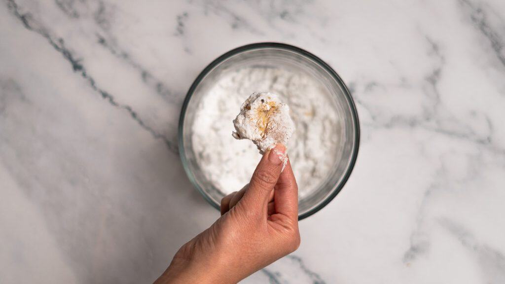 A piece of raw chicken thigh coated in potato starch
