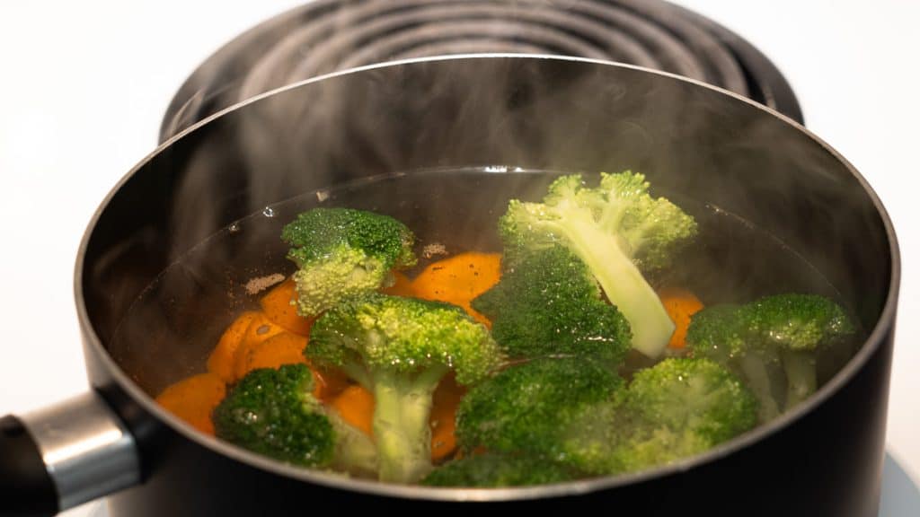 Boiling broccoli and carrots in a saucepan