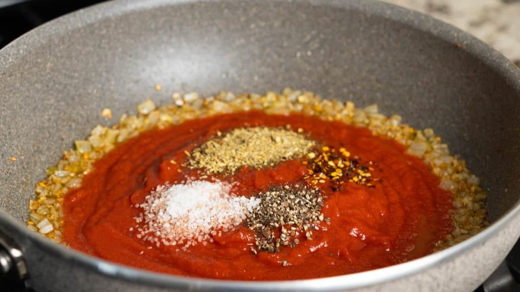 Tomato sauce on diced onions with spices on top