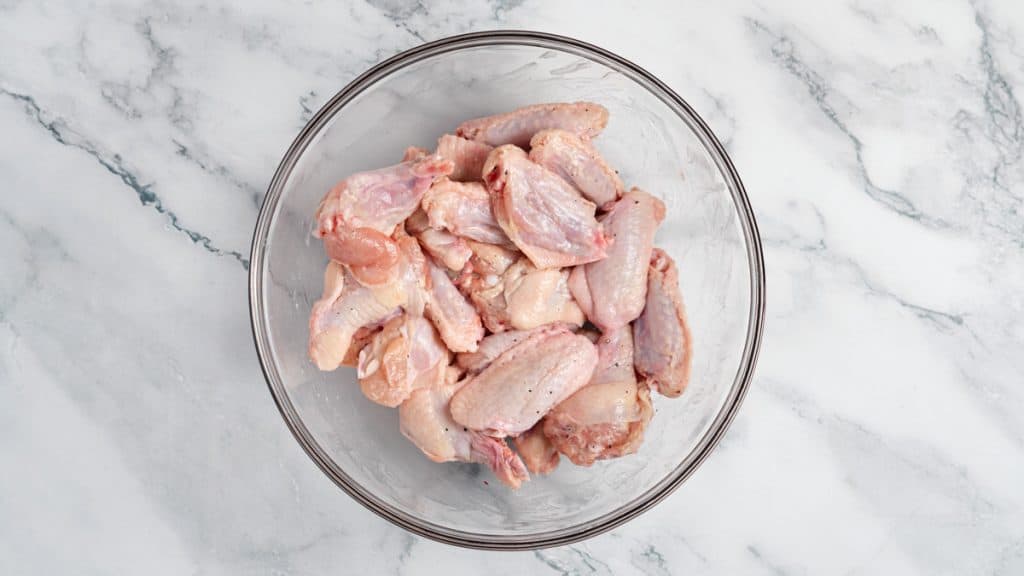 Raw chicken wings seasoned with salt and black pepper