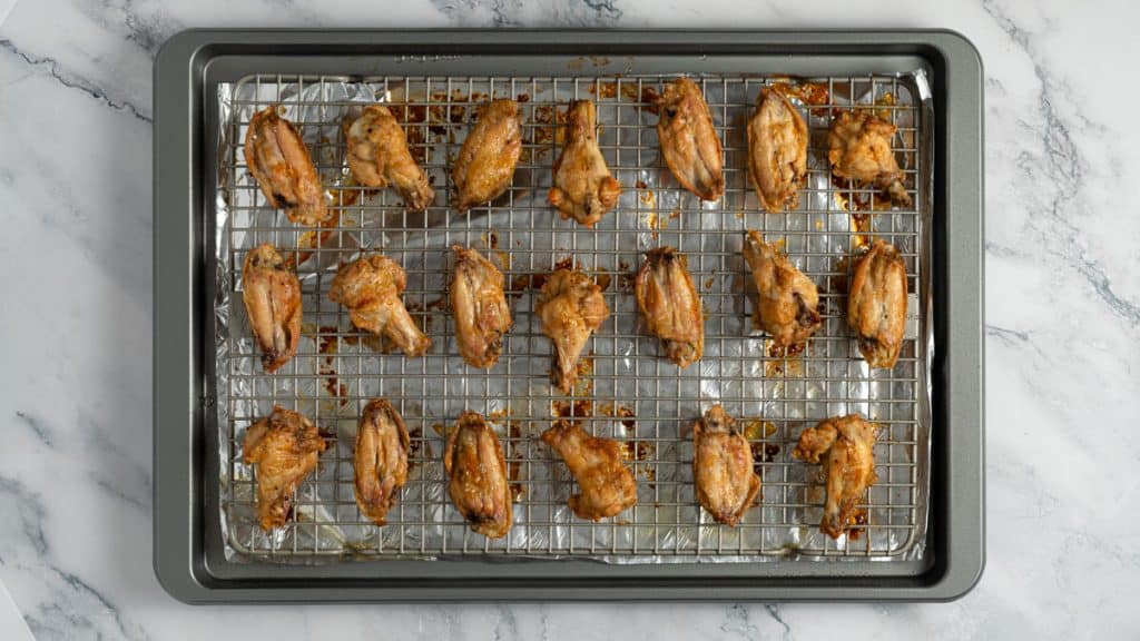 Baked soy garlic chicken wings on a baking rack on a baking sheet