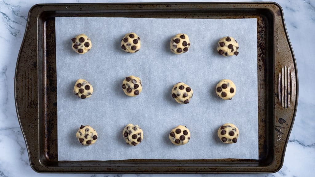 Chocolate chip cookie dough balls on a baking tray