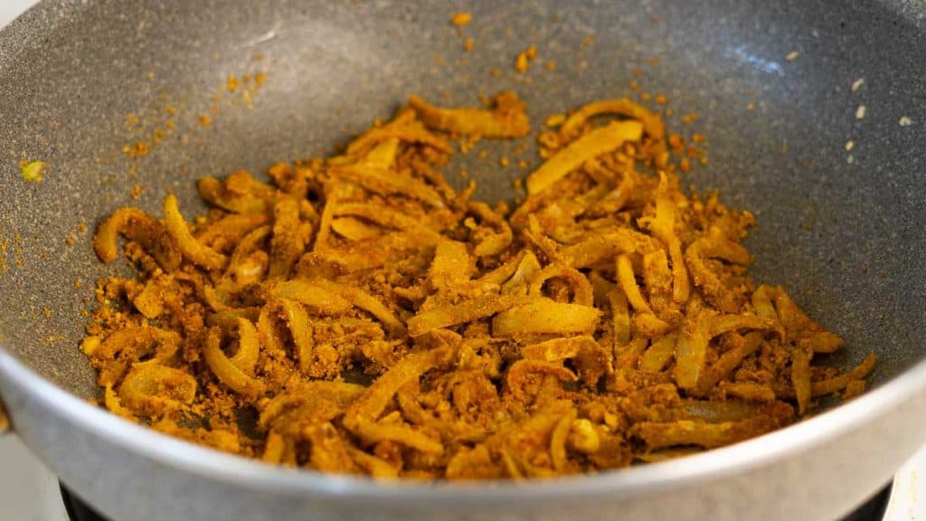 Onions and garlic mixed with spices in a pan