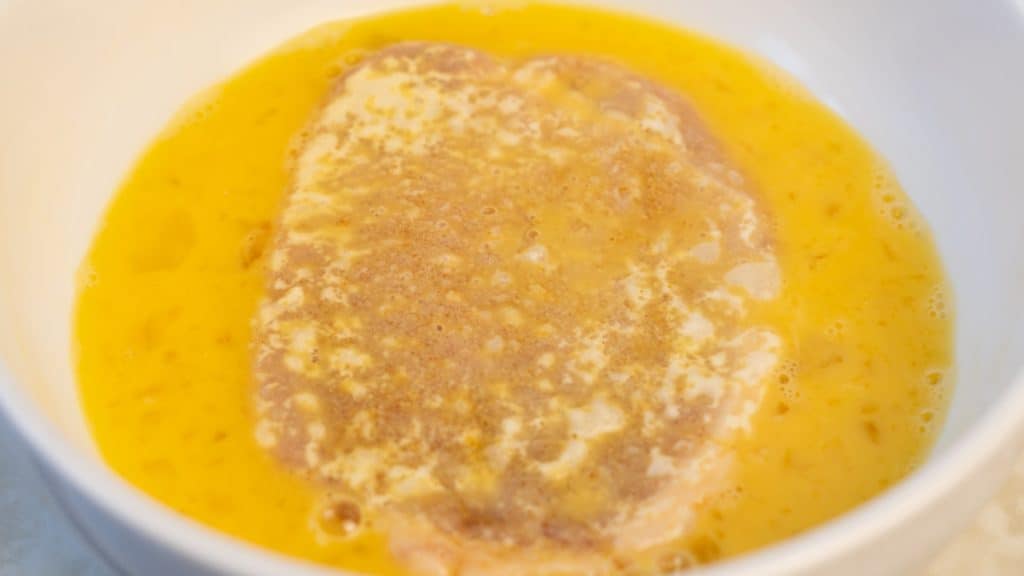 Floured pork loin in beaten egg