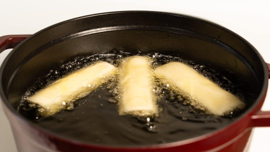Deep frying spring rolls in oil in a Dutch oven