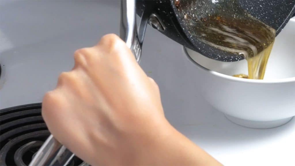 Pouring beef fat from skillet into a bowl