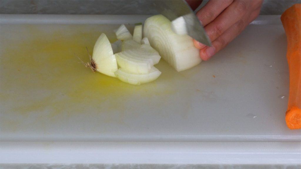 Dicing an onion on a white cutting board