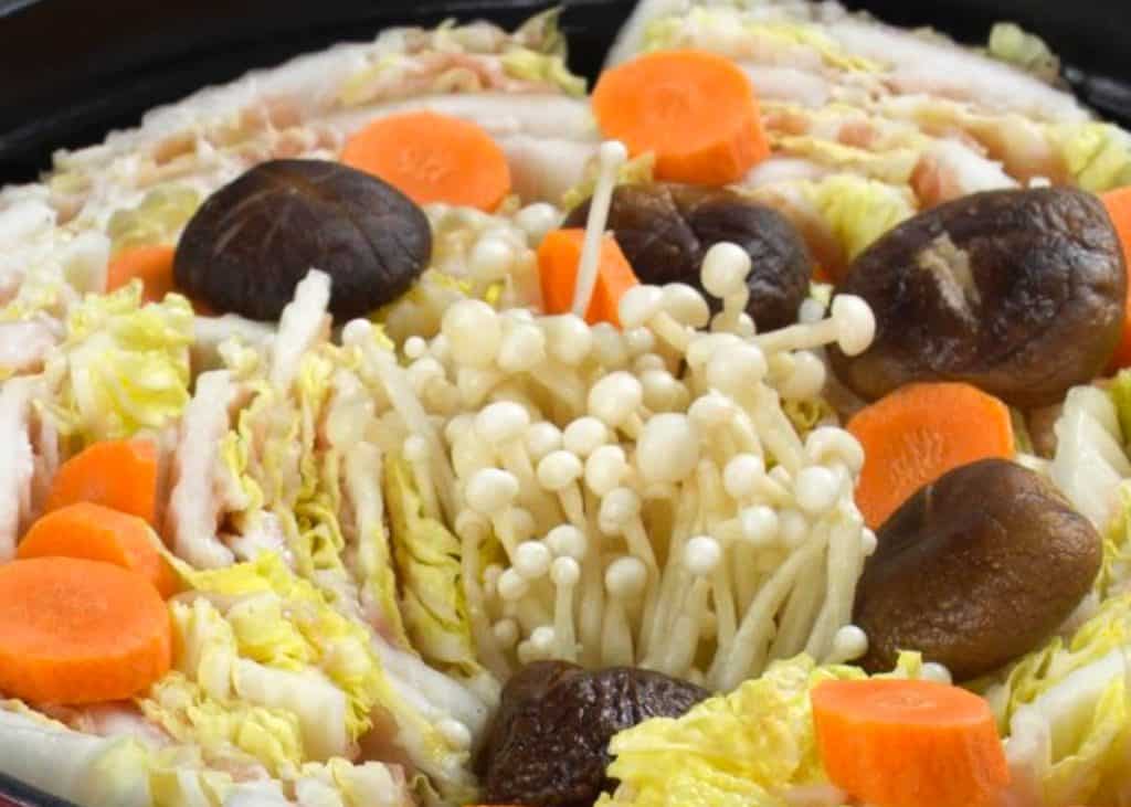 Mille feuille nabe with napa cabbage, pork belly, enoki mushrooms, shiitake mushrooms, and carrot