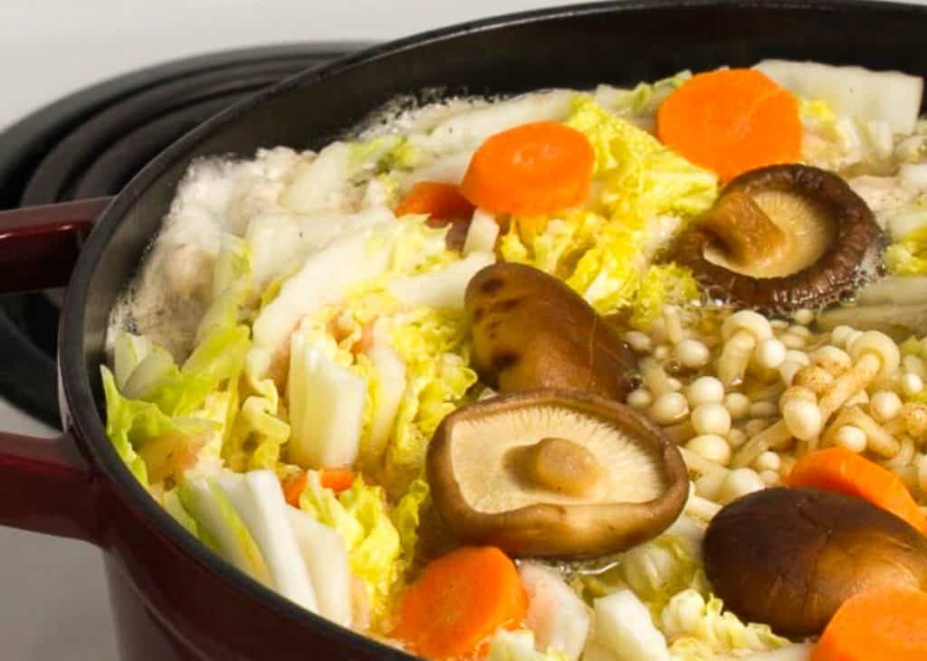 Simmering mille feuille nabe in a Dutch oven over an electric stove