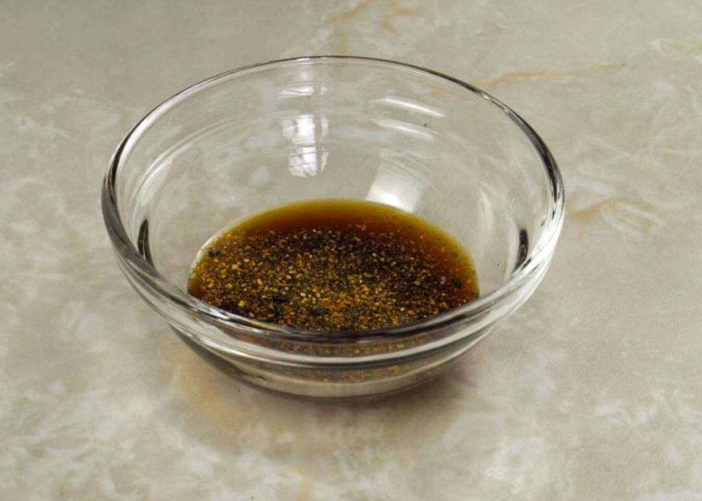 Ponzu sauce mixed with shichimi togarashi in a small glass bowl 