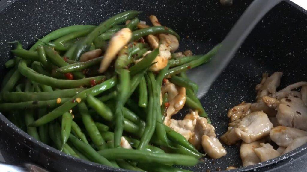 Stir frying green beans and chicken with chili peppers