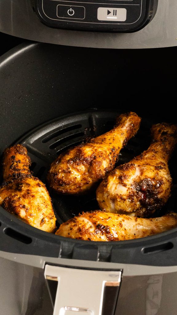 Air fried spicy chicken drumsticks in an air fryer basket
