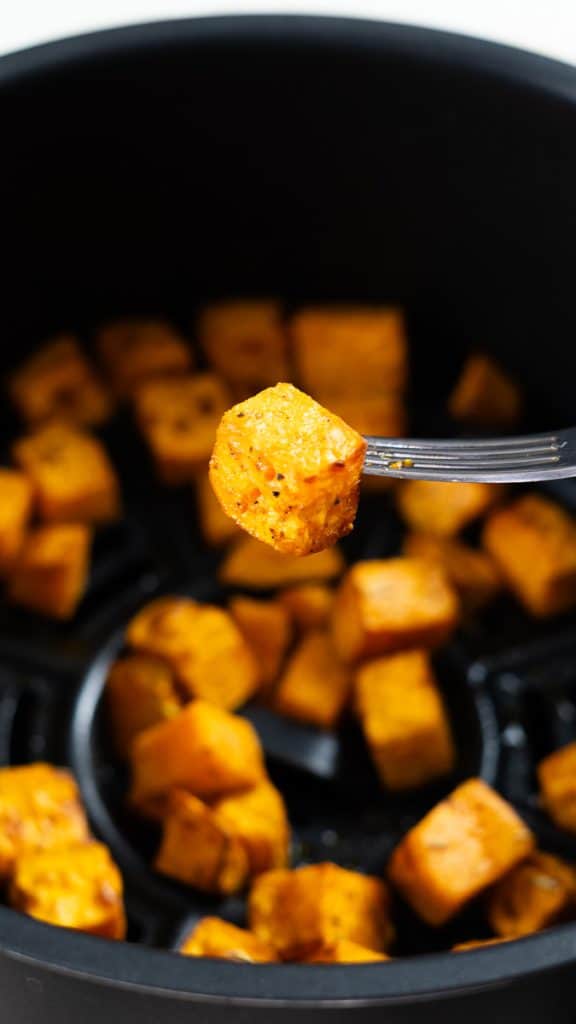 Air fried diced sweet potato in an air fryer basket