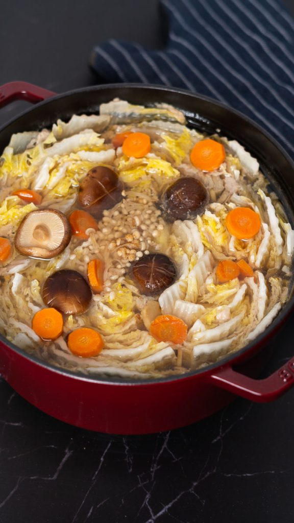 Mille feuille nabe with napa cabbage, shiitake mushrooms, carrots and pork belly and enoki mushrooms in the middle