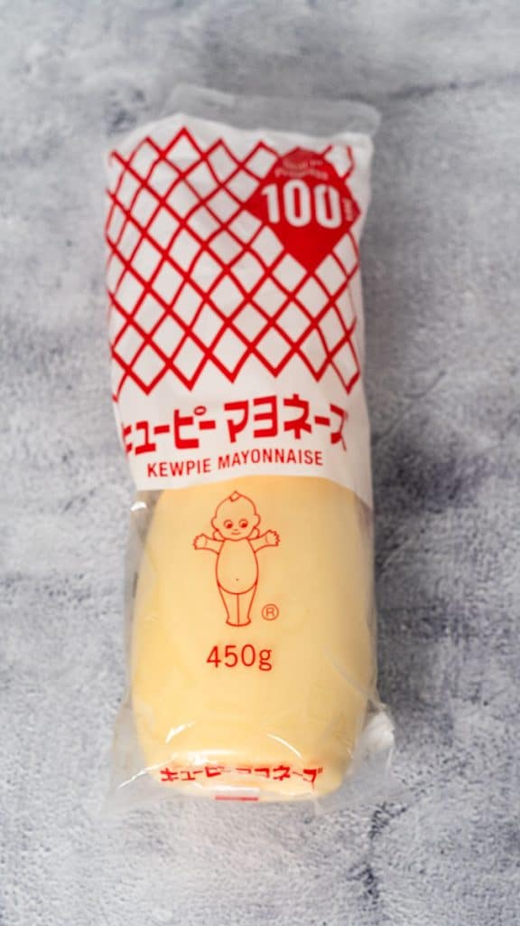 A bottle of kewpie mayo on a rustic surface