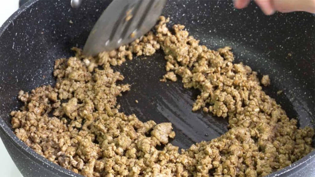 Pan-frying seasoned ground pork in a pan